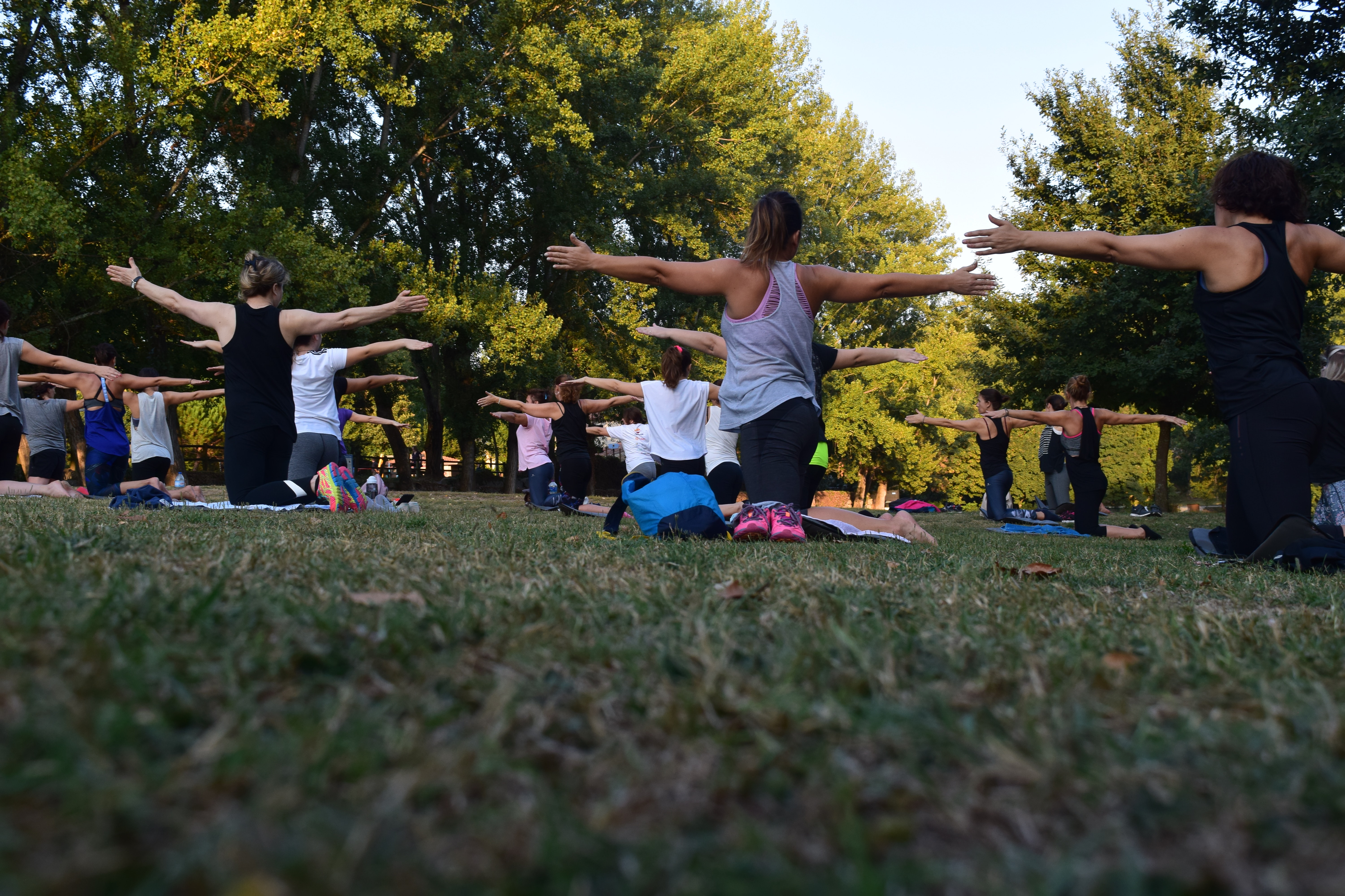 women-performing-yoga-on-green-grass-near-trees-1472887